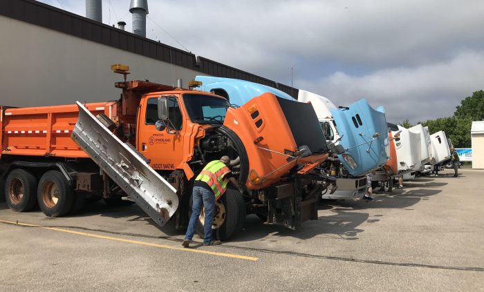 Line of semi trucks with their hoods open