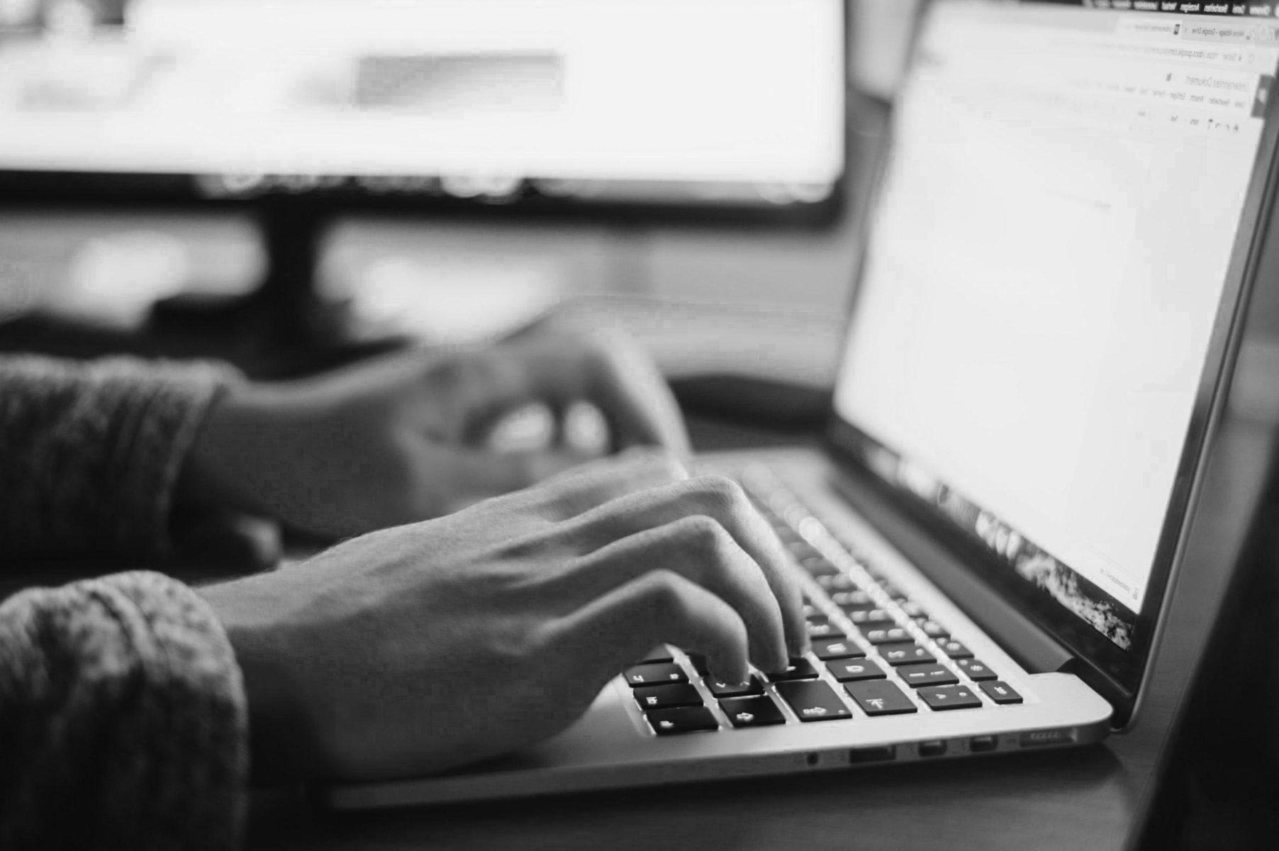 hands typing on a laptop