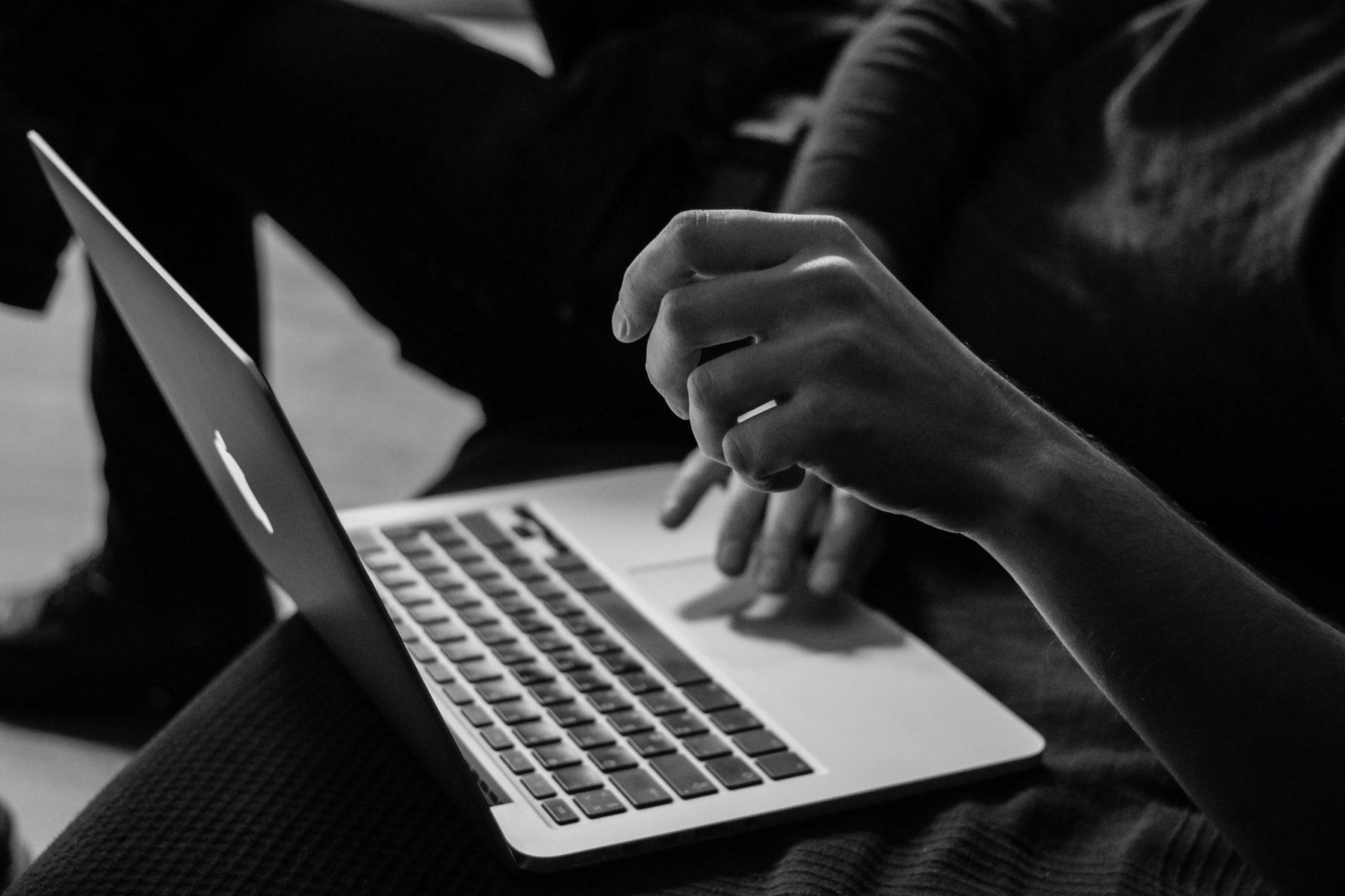 hands scrolling on a laptop