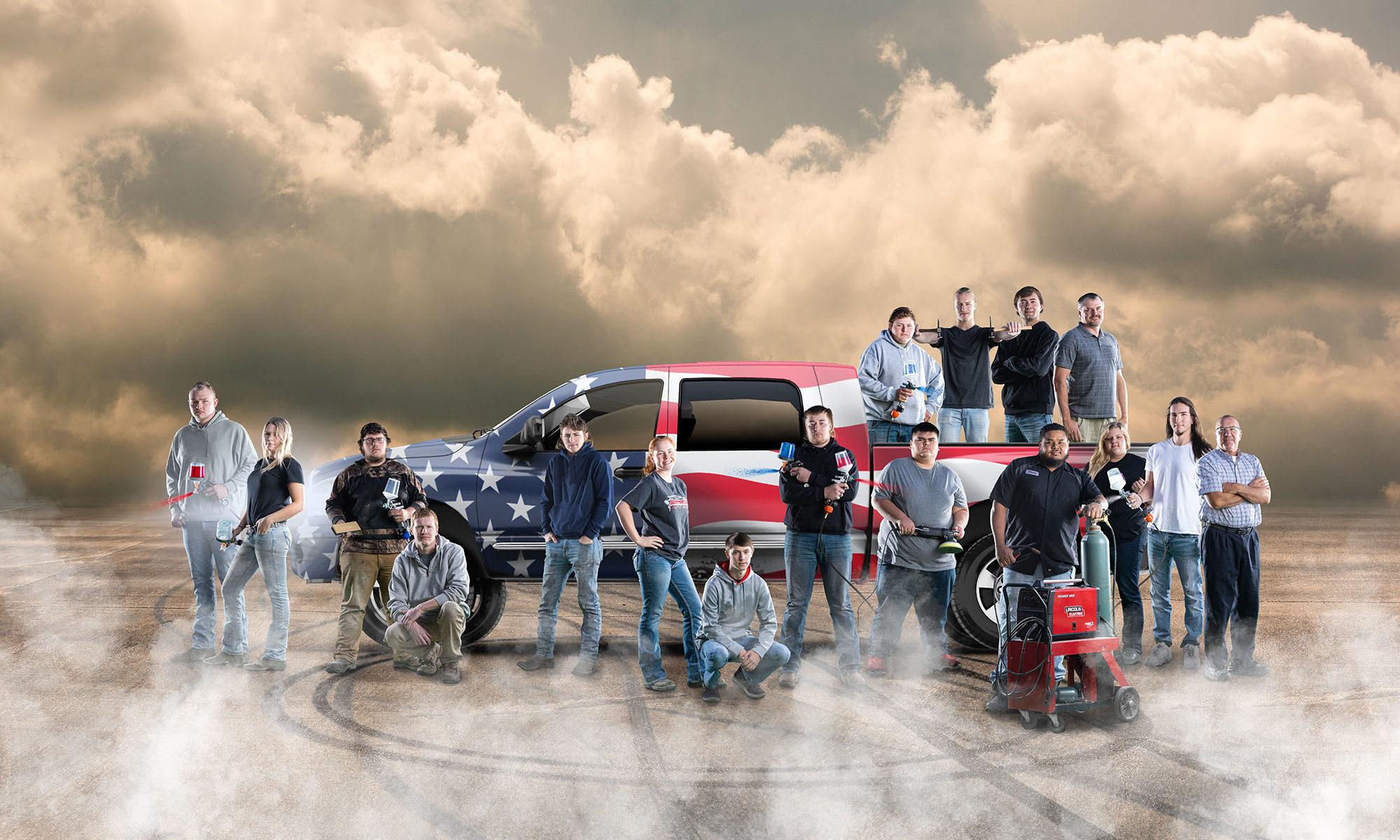auto body collision students standing in front of a truck with an American flag wrap