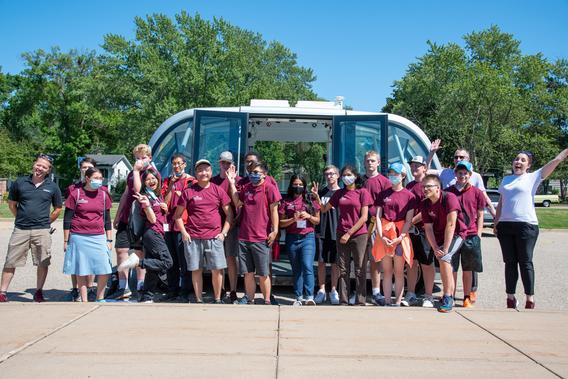 CAV X campers standing in front of an autonomous shuttle