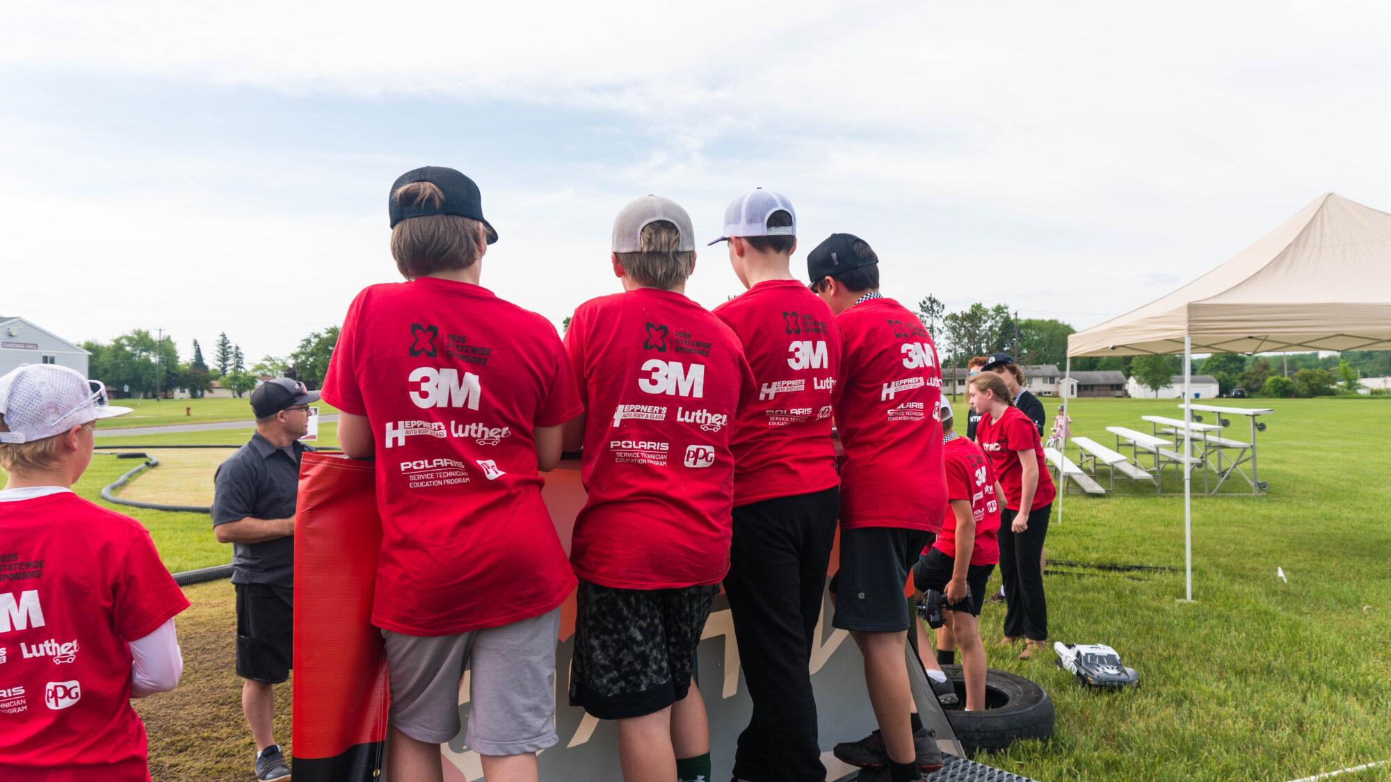 campers on racing platform showcasing sponsorship t-shirts