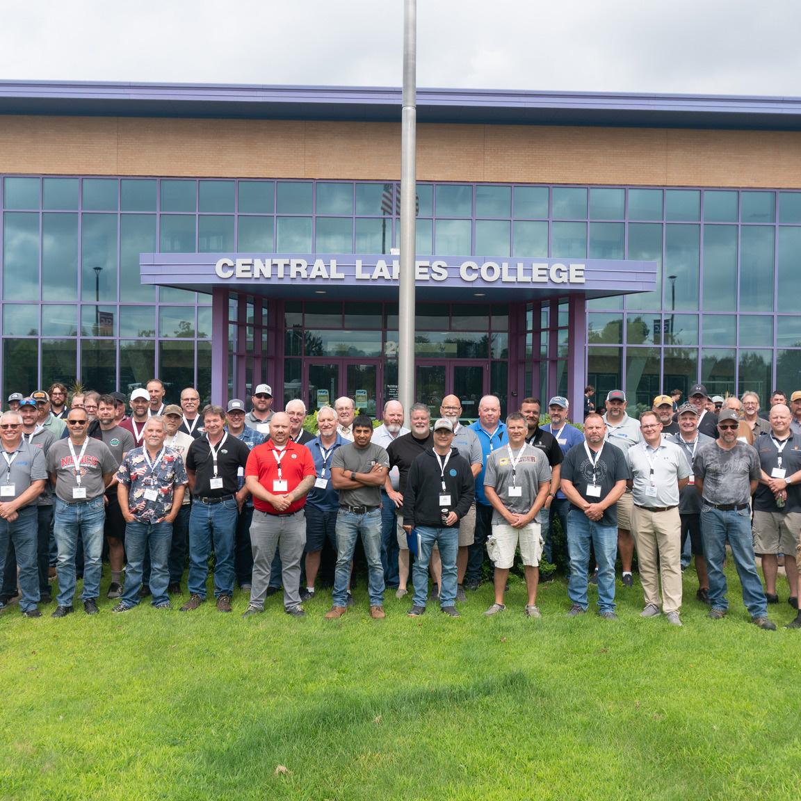Conference attendees standing outside of a building posing for a photo